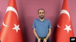 Selahaddin Gulen, a nephew of U.S.-based Muslim cleric Fethullah Gulen, stands between Turkish flags in this photo provided by the Turkish intelligence service, in Ankara, Turkey, May 31, 2021. 