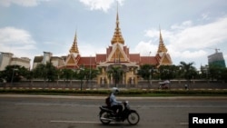 រូបឯកសារ៖ ពលរដ្ឋម្នាក់ធ្វើដំណើរ​កាត់​​អគារ​វិមាន​រដ្ឋសភា​ជាតិ​ នៅ​រាជធានី​ភ្នំពេញ​ កាល​ពី​ថ្ងៃ​ទី​២៦ ខែ​សីហា ឆ្នាំ​២០១៤។