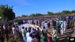 People attend a funeral for those killed by suspected Boko Haram militants in Zaabarmar, Nigeria, Sunday, Nov. 29, 2020. Nigerian officials say suspected members of the Islamic militant group Boko Haram have killed at least 40 rice farmers and…