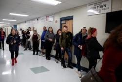 FILE - New voters, including many University of New Hampshire students, stand in line to fill out voter registration forms in Durham, New Hampshire, Nov. 6, 2018.