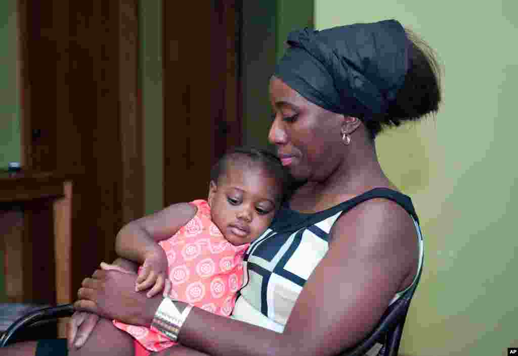 Liberiya hukumati rasmiysi sifatida Nigeriyaga kelib ishlagan, ayni paytda AQSh fuqarosi bo&#39;lgan Patrik Soyerning xotini Dekonti Soyer bir yoshli farzandi bilan, Minnesota, 29-iyul, 2014-yil.