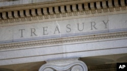 FILE- The U.S. Treasury Department building is shown at dusk in Washington on June 6, 2019. The Treasury on March 20, 2024, imposed sanctions on two Russians and their companies in relation to disinformation websites.