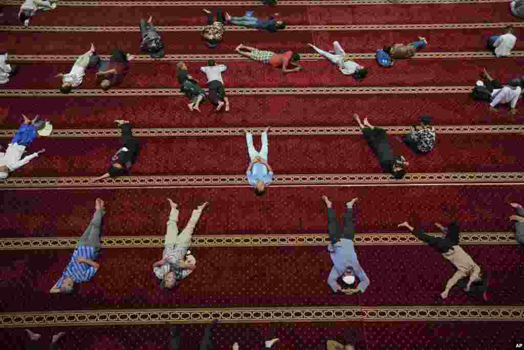 Beberapa pria Muslim beristirahat setelah usai salat Jumat pertama di bulan puasa Ramadan di Masjid Istiqlal di Jakarta. (Tatan Syuflana/AP) 