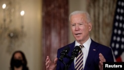 Presiden Joe Biden menyampaikan pidato kebijakan luar negeri saat Wakil Presiden Kamala Harris mendengarkan, di Departemen Luar Negeri di Washington, 4 Februari 2021. (Foto: Reuters)