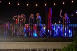 Patrons stand on the Bear Trap's rooftop bar on The Strip, the University of Alabama's bar scene, Aug. 15, 2020, in Tuscaloosa, Alabama.