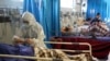 A medic treats a patient infected with the new coronavirus, at a hospital in Tehran, Iran, Sunday, March 8, 2020. 