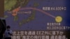 Orang-orang berjalan di depan layar yang menampilkan laporan berita tentang Korea Utara yang menembakkan rudal balistik ke Jepang, di Tokyo, Jepang, 4 Oktober 2022. (Foto: REUTERS/Issei Kato)