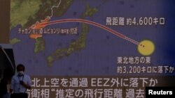 Orang-orang berjalan di depan layar yang menampilkan laporan berita tentang Korea Utara yang menembakkan rudal balistik ke Jepang, di Tokyo, Jepang, 4 Oktober 2022. (Foto: REUTERS/Issei Kato)