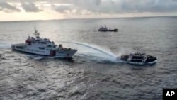 Kapal Penjaga Pantai China, kiri, menembakkan meriam air ke kapal perikanan Filipina di dekat kawasan yang disengketakan di Laut China Selatan 4 Desember 2024 (foto: dok). 