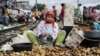 Seorang perempuan tampak mengupas kentang untuk dijual di salah satu pasar yang berlokasi dekat lintasan kereta api di Jakarta Barat, pada 1 Maret 2016. (Foto: Reuters/Garry Lotulung)