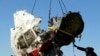 FILE - Local workers transport a piece of the Malaysia Airlines flight MH17 wreckage at the site of the plane crash near the village of Hrabove (Grabovo) in Donetsk region, eastern Ukraine, Nov. 20, 2014.
