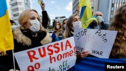 Warga Ukraina yang tinggal di Jepang memegang plakat dan bendera selama unjuk rasa mengecam Rusia atas tindakannya di Ukraina, dekat Kedutaan Rusia di Tokyo, Jepang 23 Februari 2022. (Foto: Reuters)