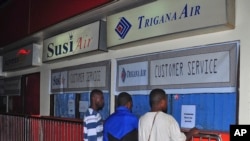 Keluarga penumpang pesawat Trigana Air yang hilang berdiri di depan loket Trigana Air yang tutup di bandara Sentani di Jayapura, Papua (16/8). 