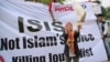 FILE - A Muslim woman releases a dove as a symbol of peace during a rally against the Islamic State group in Jakarta, Indonesia, Sept. 5, 2014.