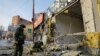 Fuerzas militares rusas inspeccionan los daños a una tienda seriamente dañada durante un bombardeo en la región ucrania de Donetsk, ocupada por Rusia, el 19 de febrero de 2023. 
