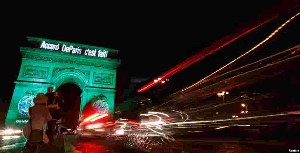 The Arc de Triomphe is illuminated in green with the words "Paris Agreement is Done," to celebrate the Paris U.N. COP21 Climate Change agreement in Paris, France.