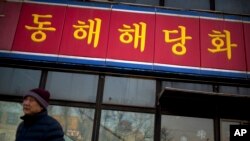 Seorang pria berjalan melewati cabang restoran Korea Utara Haedanghwa di Beijing, China (Foto: dok)..