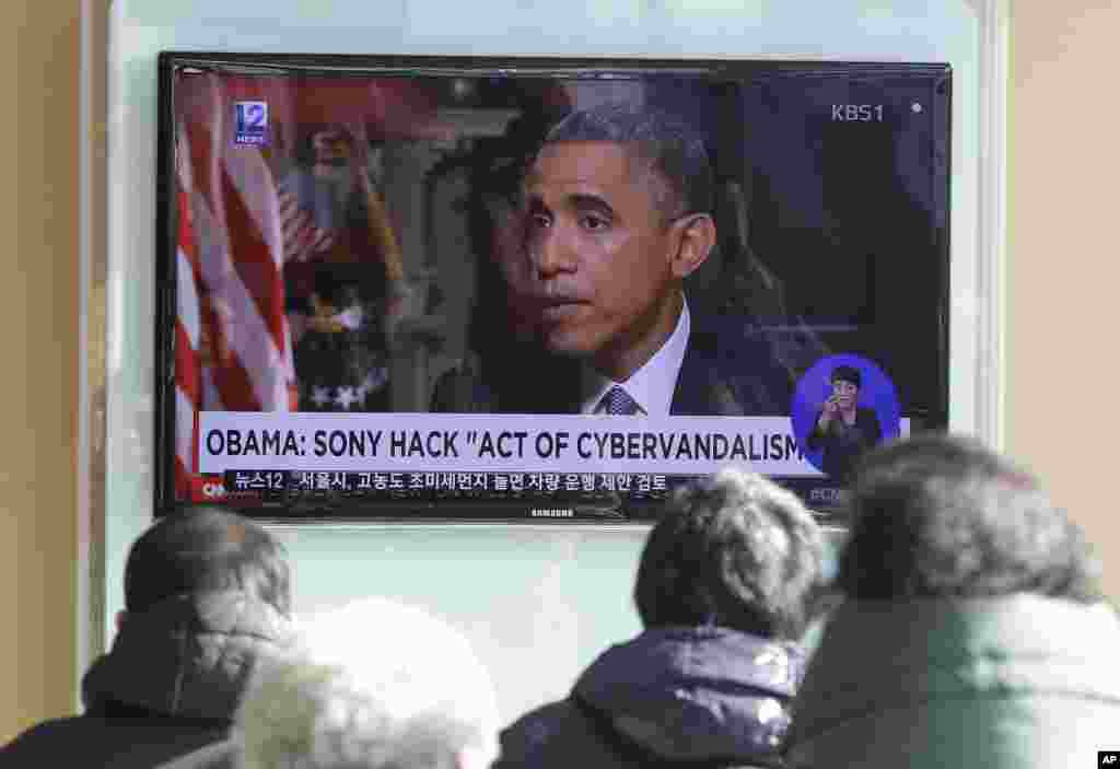 Warga menonton siaran berita televisi yang memperlihatkan Presiden AS Barack Obama di stasiun kereta api Seoul, Korea Selatan (22/12). ​(AP/Ahn Young-joon)
