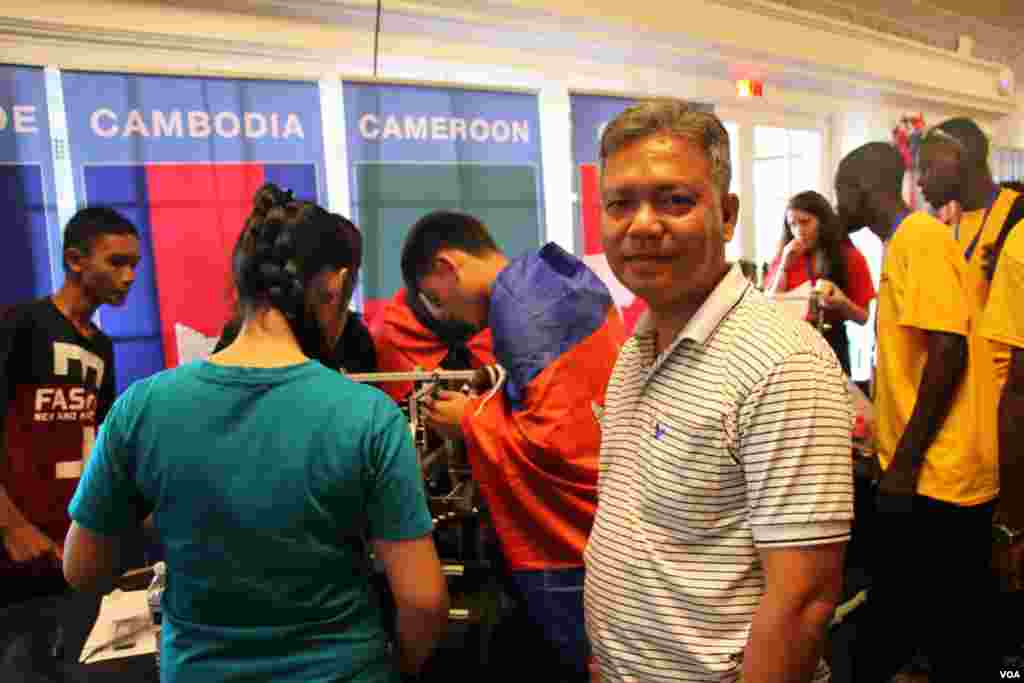Ung Savy, Country Director &amp; Superintendent of Caring For Cambodia, which sponsors the Cambodian youth robotics team stands next to the team at the First Global Challenge robotics competition in Washington, DC, Monday, July 17, 2017. (Sophat Soeung/VOA Khmer)