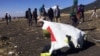 Warga tampak berjalan melintasi sebagian dari reruntuhan di TKP jatuhnya Ethiopian Airlines no penerbangan ET302, dekat kota Bishoftu, tenggara Addis Ababa, Ethiopia, 10 Maret 2019 (foto: Reuters/Tiksa Negeri)