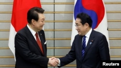 Perdana Menteri Jepang Fumio Kishida bersalaman dengan Perdana Menteri Jepang Fumio Kishida saat pertemuan di kediaman resmi Kishida di Tokyo, Jepang, 16 Maret 2023. (Foto: Kiyoshi Ota/Pool via Reuters)