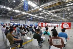 FILE - People wait to be vaccinated against the coronavirus disease (COVID-19) during a vaccination session organized by the local Taiwan Affairs Office in Nanchang, Jiangxi province, China June 4, 2021.