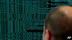 Seorang tentara Perancis mengamati garis kode di komputernya di stand Kementerian Pertahanan Perancis dalam forum Cybersecurity Internasional di Lille, Perancis utara, 23 Januari 2018. (Foto: dok).