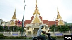 រូបឯកសារ៖ បុរស​ម្នាក់​បើក​ម៉ូតូ​កាត់​មុខ​អគារ​រដ្ឋ​សភា​ក្នុង​ក្រុង​ភ្នំពេញ កាលពី​ល្ងាច​ថ្ងៃ​ទី២ ខែឧសភា ឆ្នាំ២០១៨។ (អូន ឆេងប៉រ/វីអូអេ)