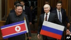 Ruski predsednik Vladimir Putin i lider Severne Koreje Kim Džong Un osmehuju se tokom sastanka na međunarodnom aerodromu Pjongjang Sunan u blizini Pjongjanga, Severna Koreja, 19. juna 2024. (Gavriil Grigorov, Sputnjik, Kremlj pul foto preko AP-a)