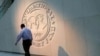 Seorang pria berjalan melewati logo Dana Moneter Internasional (IMF) di kantor pusatnya di Washington, AS, 10 Mei 2018. (Foto: REUTERS/Yuri Gripas)