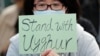 FILE - A man holds a sign during a rally to show support for Uyghurs and their fight for human rights, in Hong Kong, Dec. 22, 2019.