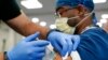Seorang petugas kesehatan menerima suntikan booster vaksin COVID-19 Pfizer di Jackson Memorial Hospital in Miami pada 5 Oktober 2021. (Foto: AP/Lynne Sladky)