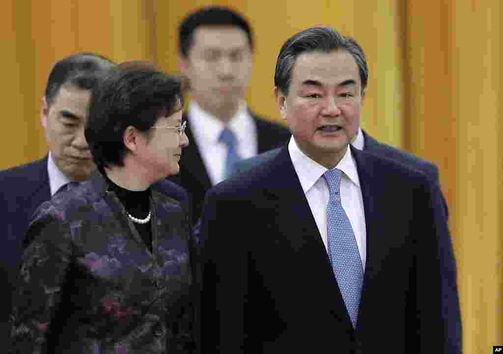 Menteri Luar Negeri China Wang Yi (kanan) berbincang dengan seorang delegasi saat menghadiri sebuah upacara. China mengatakan pada AS bahwa mereka menolak serangan dunia maya tapi tidak secara langsung mengutuk peretasan atas Sony Pictures (22/12). ​(AP/Andy Wong)