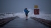 Warga setempat, John Smith menggendong putranya yang baru berusia 18 bulan, Owen, berdiri di tepi pantai Galveston, Texas, menjelang badai tropis Nicholas, 13 September 2021. (REUTERS/Adrees Latif/File Photo)