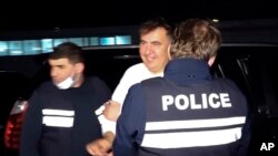 Tampak polisi Georgia membawa mantan presiden Mikheil Saakashvili setelah ia berhasil ditahan di Rustavi, georgia, pada 1 Oktober 2021. Saakashvili sebelumnya hidup dalam pengasingan di Ukraina selama delapan tahun. (Foto: Georgian Interior Ministry Press Service via AP)