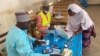 Une électrice signe après avoir voté lors des premières élections régionales à Maroua, Cameroun, le 6 décembre 2020.
