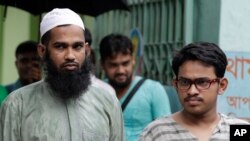 Tersangka Saad-al-Nahin (kanan) and Masud Rana, yang ditahan atas pembunuhan seorang blogger, berdiri di depan media di Dhaka, Bangladesh (14/8).