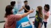 Para guru memeriksa suhu tubuh para siswa yang masuk sekolah untuk program Summer Camp di sebuah SMU kota Wylie, Texas di tengah pandemi Covid-19 yang terus bertambah di AS.