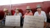 Villagers shout slogans during a protest against a recent report of a commission which investigated the Letpadaung mine's operations and a police crackdown last November that badly injured scores of protesters, during a visit by Myanmar opposition leader 