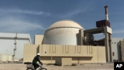 Seorang pengendara sepeda melewati pembangkit listrik tenaga nuklir di luar Bushehr, Iran, 26 Oktober2010. Wakil AS dan Iran akan bertemu sebelum perundingan selanjutnya mengenai nuklir dengan negara-negara kuat dunia. (Foto: dok)