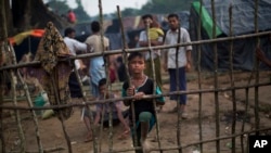 Seorang anak Rohingya, yang baru tiba dari Myanmar di sisi perbatasan Bangladesh, berdiri di sebuah pagar kayu di kamp pengungsi Kutupalong di Ukhia, 5 September 2017.