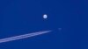 Sebuiah jet tempur terbang melintasi balon yang berada di atas Samudra Atlantik, di lepas pantai South Carolina, pada 4 Februari 2023. (Foto: Chad Fish via AP)