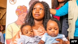Noah Ngah (L), jariri na farko da ta karbi allurar ragakafin cutar cizon sauro da yayarsa, Judith Ndzie, a asibitin na Soa, Cameroon, Janairu 22, 2024.