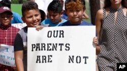 Anak-anak imigran Latin memberikan dukungan kepada orang tua yang ditangkap petugas imigrasi, dengan ikut aksi unjuk rasa ke Gedung Pengadilan Madison di Canton, Mississippi, 11 Agustus 2019.