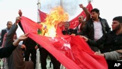 Iroqning Basra shahrida namoyishchilar Turkiya bayroqlarini yoqmoqda, Anqaradan qo'shinlarini chiqarishni talab qilmoqda, 18-dekabr, 2015-yil