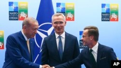 Presiden Turki Recep Tayyip Erdogan (kiri) menjabat tangan Perdana Menteri Swedia Ulf Kristersson (kanan) ketika bertemu menjelang KTT NATO di Vilnius, Lituania, pada 10 Juli 2023. (Foto: Yves Herman, Pool Foto via AP)