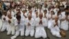 People wearing white pray as they mourn Cambodia's former King Norodom Sihanouk in front of the Royal Palace in Phnom Penh, October 15, 2012.