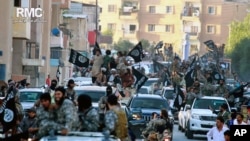 Para tentara ISIS berparade di Raqqa, Suriah utara, 30 Juni 2014. Menurut mantan kepala intelijen Inggris, jumlah militan ISIS bertambah pada saat itu setelah merekrut tentara asing. 