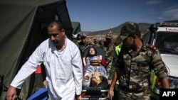 Personil militer mengangkut korban gempa di rumah sakit lapangan militer di desa Asni dekat Moulay Brahim di provinsi al-Haouz, 11 September 2023. (Philippe Lopez/AFP)