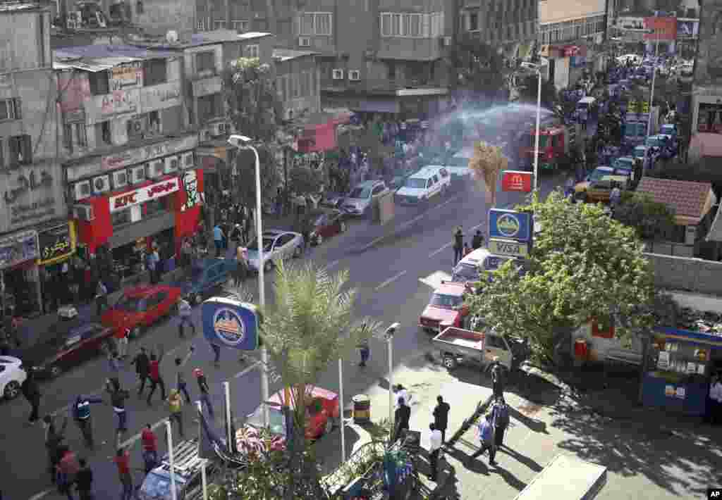 Police fire a water cannon to disperse a protest by dozens of activists commemorating the death of a protester a year earlier, Cairo, Nov. 26, 2013.